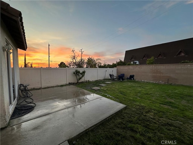 yard at dusk with a fenced backyard and a patio