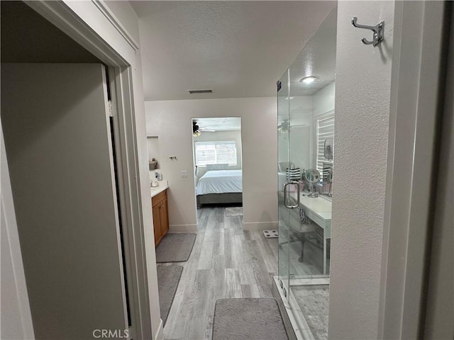 full bathroom featuring a shower stall, wood finished floors, a textured ceiling, ensuite bathroom, and visible vents
