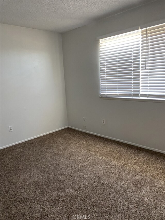 3408 20th St, Highland, CA 92346 - carpeted spare room with a textured ceiling and baseboards