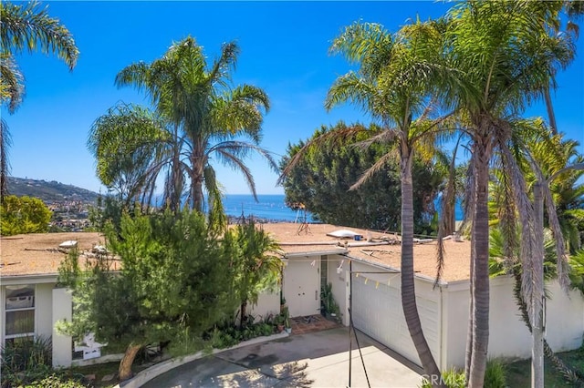 1223 Skyline Dr, Laguna Beach, CA 92651 - view of front of home featuring stucco siding, concrete driveway, a garage, and a water view