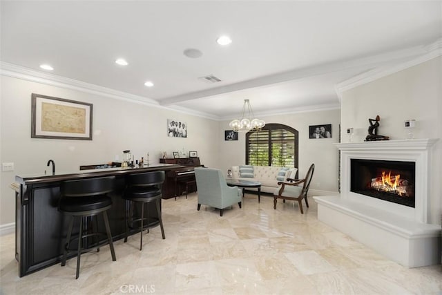 dining area featuring indoor wet bar, a warm lit fireplace, recessed lighting, crown molding, and visible vents