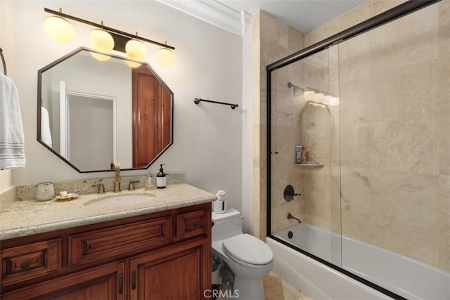 bathroom featuring enclosed tub / shower combo, vanity, crown molding, and toilet