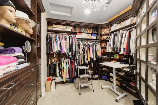 walk in closet featuring visible vents, attic access, and carpet