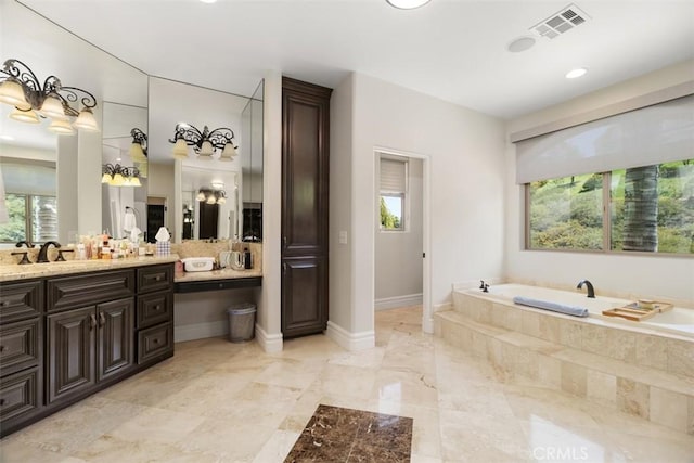 full bath with a bath, vanity, baseboards, and visible vents