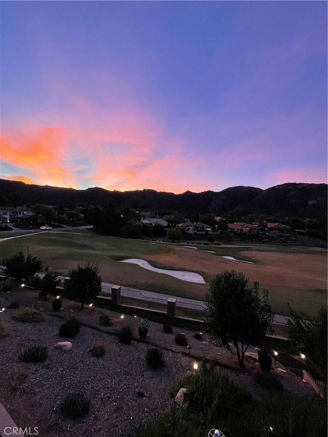 exterior space featuring a mountain view, fence, and view of golf course