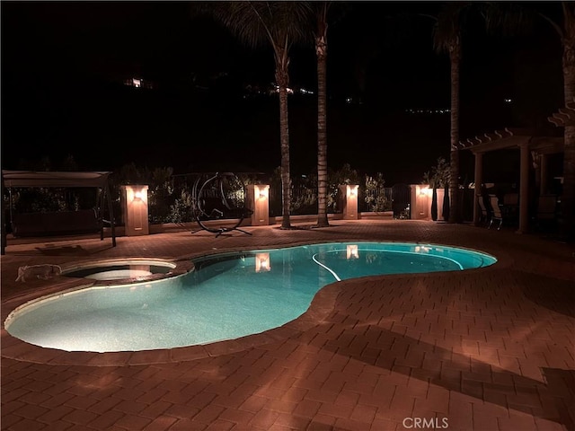 pool at twilight with a pergola, a patio area, and a pool with connected hot tub