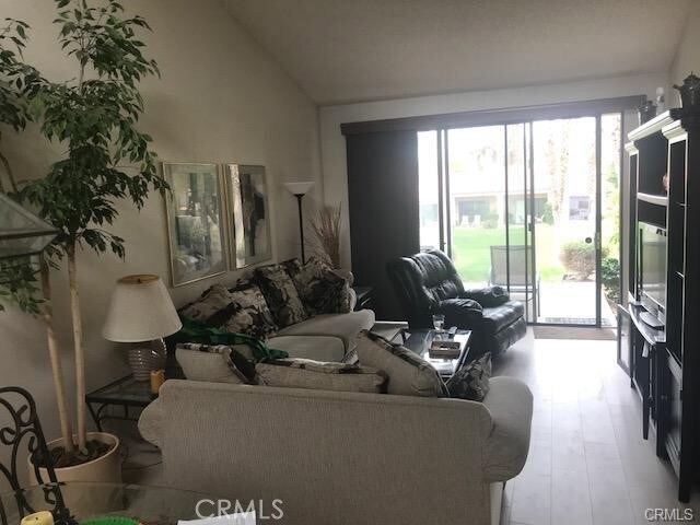 living room with vaulted ceiling and wood finished floors