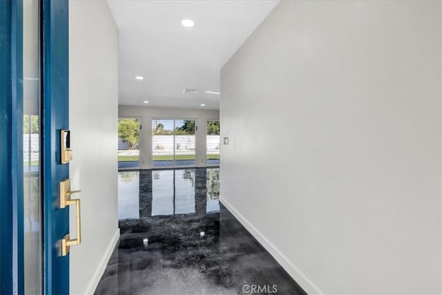 foyer entrance featuring recessed lighting, baseboards, and concrete floors