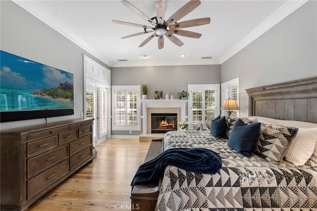 bedroom with crown molding, visible vents, light wood finished floors, and multiple windows
