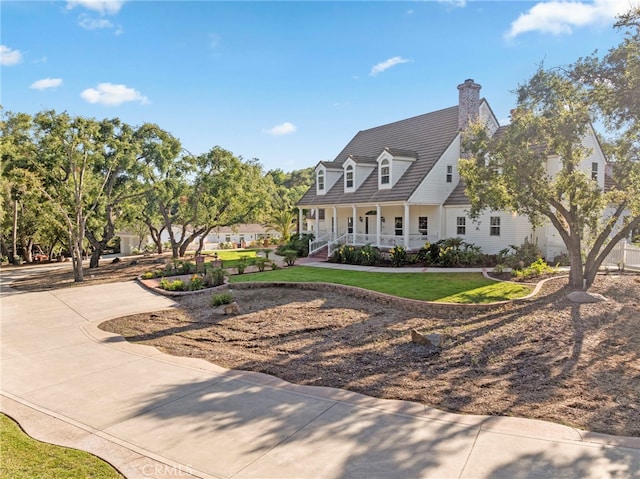 view of front of property featuring a front lawn, a porch, and a chimney
