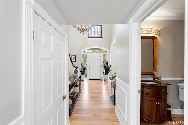 foyer with light wood finished floors and a chandelier