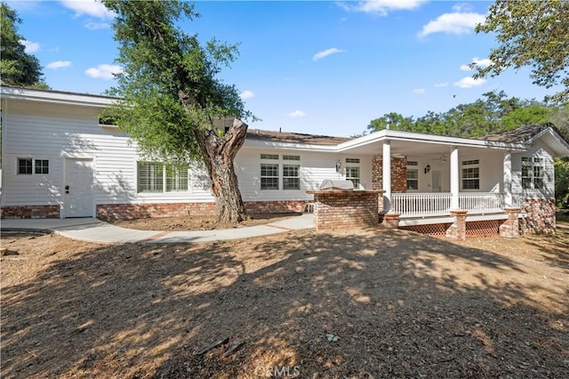 rear view of property featuring covered porch