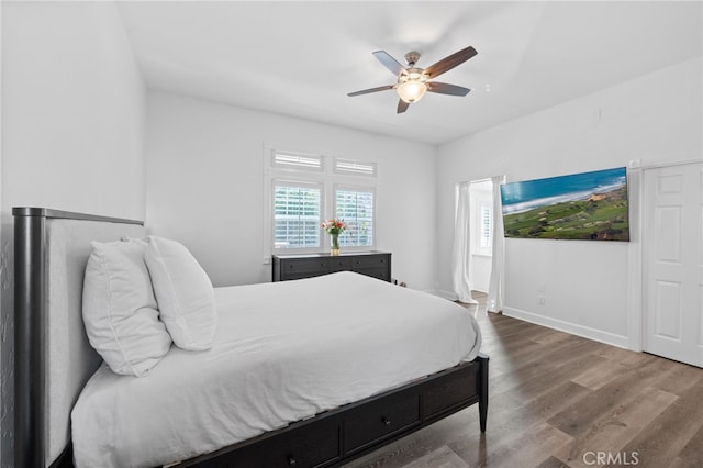 bedroom featuring baseboards, a ceiling fan, and wood finished floors