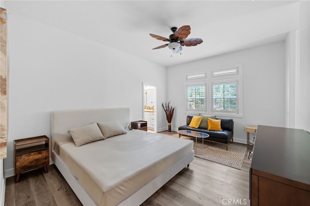 bedroom featuring connected bathroom, ceiling fan, baseboards, and wood finished floors