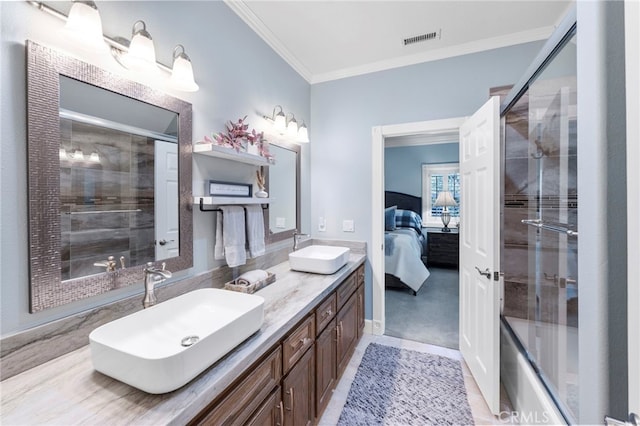 ensuite bathroom with ensuite bathroom, a sink, a shower with shower door, and ornamental molding