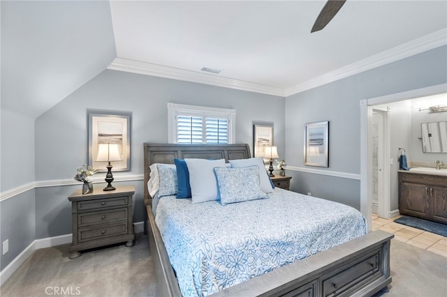bedroom with baseboards, a sink, ornamental molding, and connected bathroom