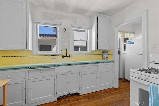 308 Catalina Ave, Avalon, CA 90704 - kitchen featuring decorative backsplash, white appliances, dark wood-style flooring, and white cabinetry