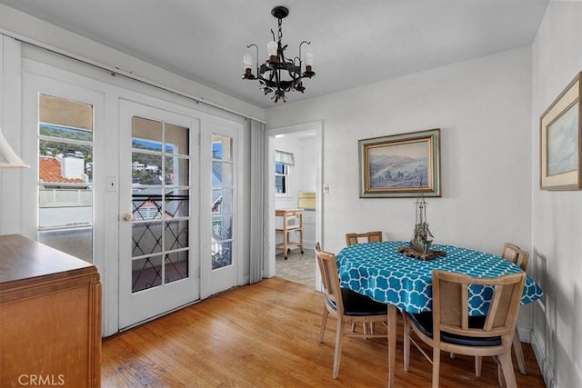 308 Catalina Ave, Avalon, CA 90704 - dining area with light wood-style floors, french doors, and a chandelier