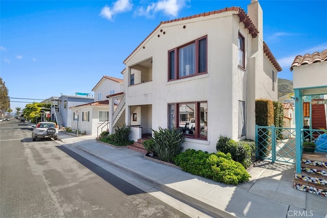 308 Catalina Ave, Avalon, CA 90704 - view of front facade featuring a residential view, stucco siding, a tiled roof, and a chimney