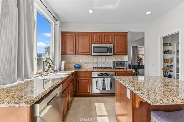 27669 Bluff Vista Way, Menifee, CA 92584 - kitchen with a sink, stainless steel appliances, light stone countertops, and a wealth of natural light