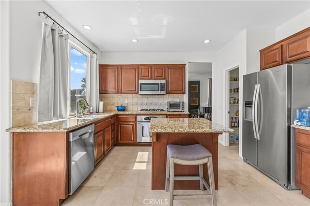 27669 Bluff Vista Way, Menifee, CA 92584 - kitchen with backsplash, a kitchen island, a toaster, appliances with stainless steel finishes, and a sink