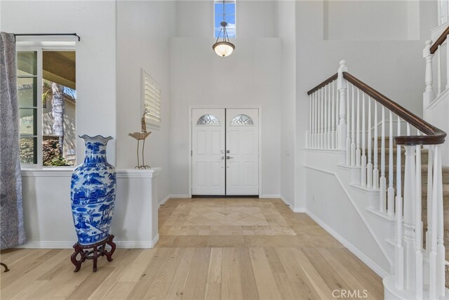 27669 Bluff Vista Way, Menifee, CA 92584 - foyer with light wood finished floors, stairs, and baseboards