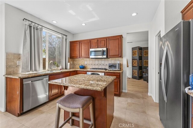 27669 Bluff Vista Way, Menifee, CA 92584 - kitchen featuring a sink, a kitchen island, backsplash, stainless steel appliances, and a toaster