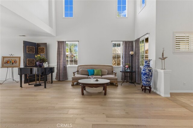 27669 Bluff Vista Way, Menifee, CA 92584 - living area featuring visible vents, a towering ceiling, baseboards, and wood finished floors
