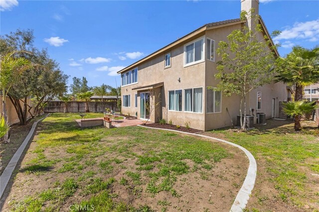 27669 Bluff Vista Way, Menifee, CA 92584 - rear view of house featuring a chimney, stucco siding, a lawn, and a fenced backyard