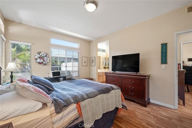 4591 Warner Ave Unit 101, Huntington Beach, CA 92649 - bedroom with light wood-style flooring, baseboards, and ensuite bathroom