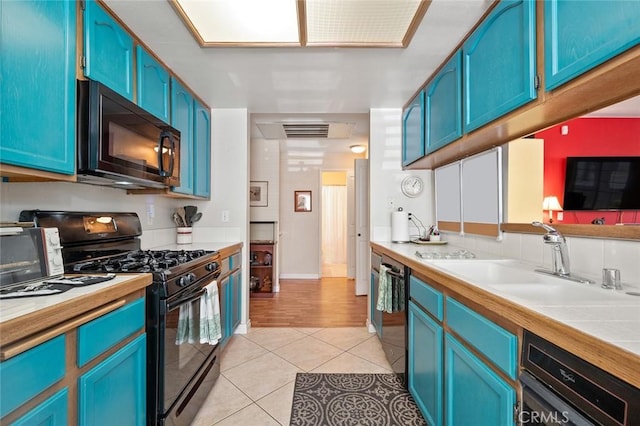 4591 Warner Ave Unit 101, Huntington Beach, CA 92649 - kitchen featuring black appliances and blue cabinets