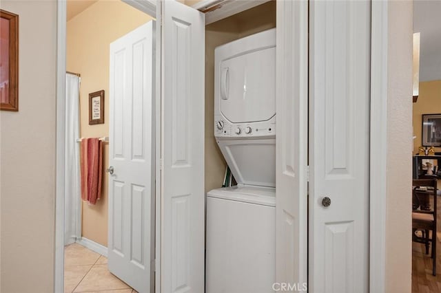 4591 Warner Ave Unit 101, Huntington Beach, CA 92649 - laundry room featuring stacked washer and clothes dryer and light tile patterned floors