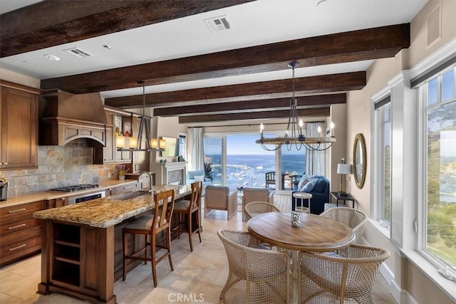 133 Upper Terrace Rd, Avalon, CA 90704 - kitchen with premium range hood, a notable chandelier, a kitchen island with sink, a sink, and tasteful backsplash