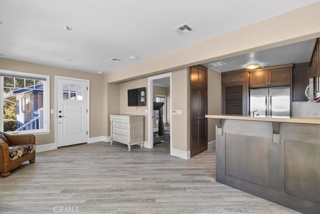 133 Upper Terrace Rd, Avalon, CA 90704 - interior space featuring light wood-type flooring, visible vents, stainless steel appliances, a peninsula, and light countertops