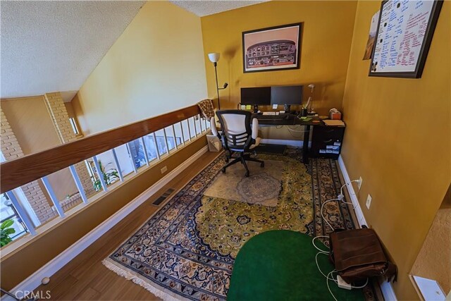 home office featuring baseboards, a textured ceiling, and wood finished floors