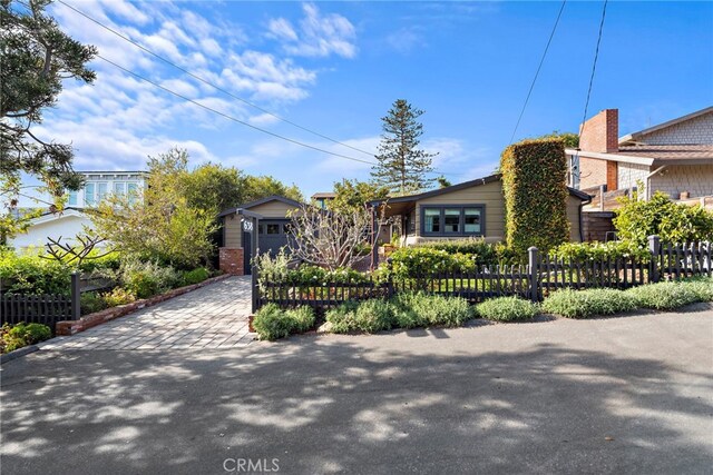 view of front facade featuring a fenced front yard, decorative driveway, and a garage