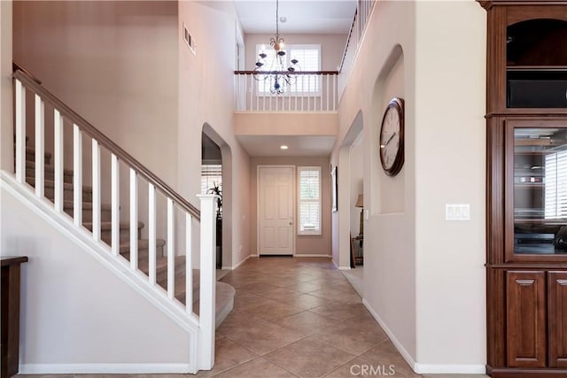 26718 Cactus Creek Way, Menifee, CA 92586 - entryway featuring a chandelier, light tile patterned flooring, arched walkways, stairway, and baseboards