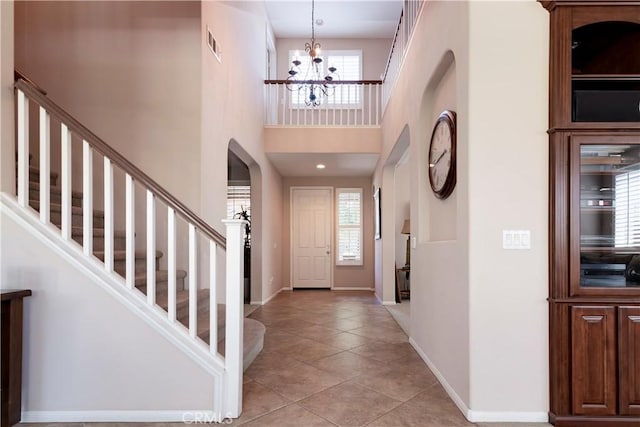 26718 Cactus Creek Way, Menifee, CA 92586 - entryway featuring a chandelier, light tile patterned floors, arched walkways, stairs, and baseboards