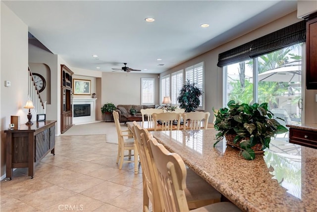 26718 Cactus Creek Way, Menifee, CA 92586 - dining area with ceiling fan, recessed lighting, light tile patterned flooring, a glass covered fireplace, and baseboards