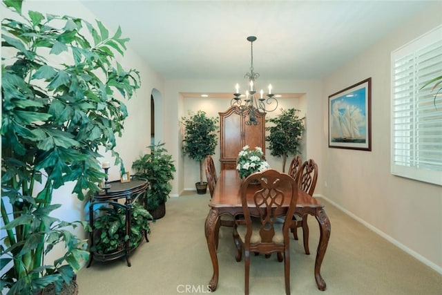 26718 Cactus Creek Way, Menifee, CA 92586 - dining space featuring a chandelier, light carpet, baseboards, and arched walkways