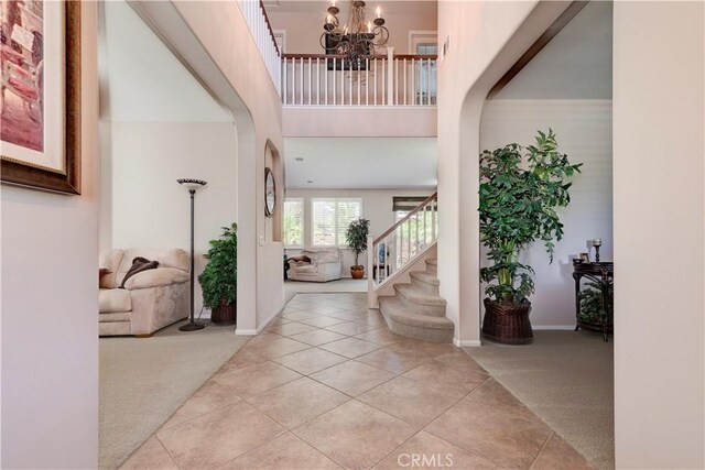 26718 Cactus Creek Way, Menifee, CA 92586 - carpeted entryway featuring a chandelier, stairway, tile patterned flooring, a high ceiling, and baseboards
