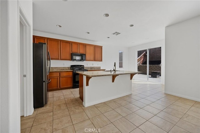 34135 Crenshaw St, Beaumont, CA 92223 - kitchen with black appliances, light tile patterned floors, light stone countertops, brown cabinetry, and recessed lighting