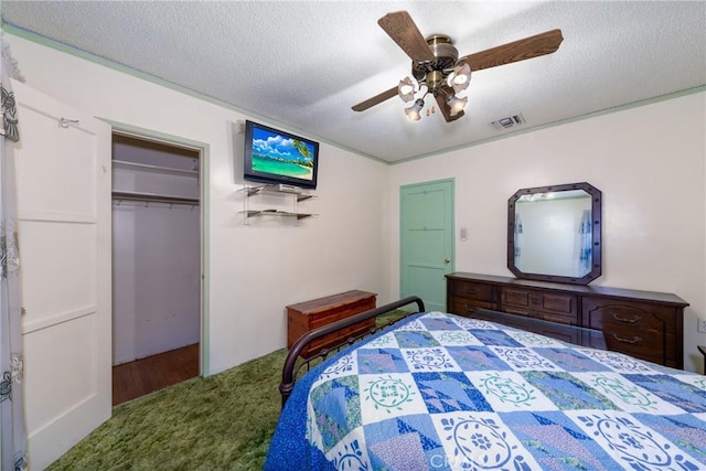 bedroom with a closet, carpet flooring, a textured ceiling, visible vents, and ceiling fan