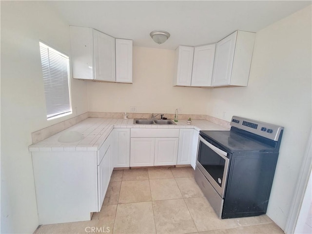 40000 140th St E, Palmdale, CA 93591 - kitchen with stainless steel electric stove, a sink, tile countertops, and white cabinetry