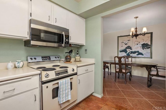 4428 Skimmer Way, Oceanside, CA 92057 - kitchen featuring stainless steel microwave, white electric range, a chandelier, dark tile patterned floors, and white cabinets