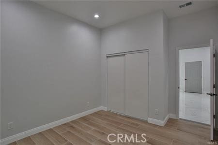 unfurnished bedroom featuring recessed lighting, wood finished floors, visible vents, and baseboards