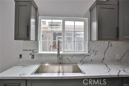 1226212266 Madras Pl, Garden Grove, CA 92840 - kitchen featuring gray cabinetry, a sink, backsplash, and light stone counters