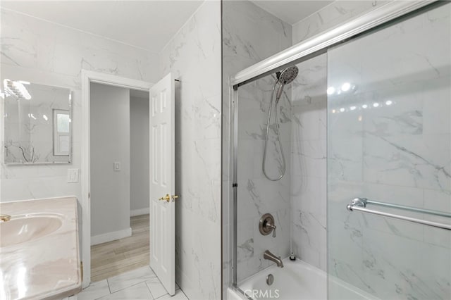 bathroom featuring vanity, marble finish floor, and shower / bath combination with glass door