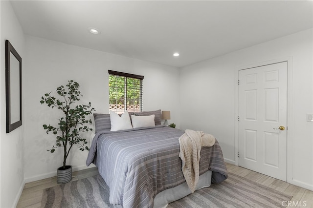 bedroom featuring light wood finished floors, baseboards, and recessed lighting