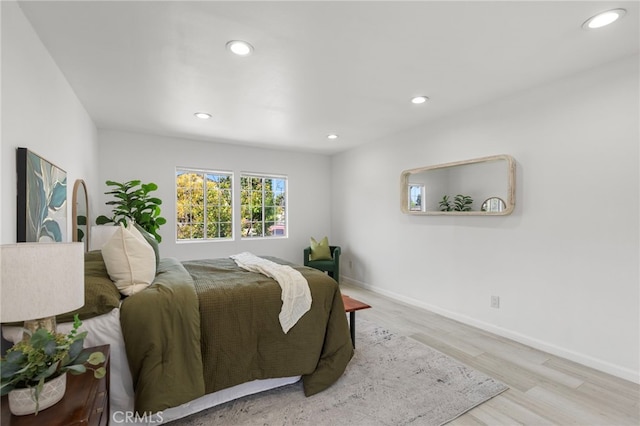 bedroom with baseboards, wood finished floors, and recessed lighting